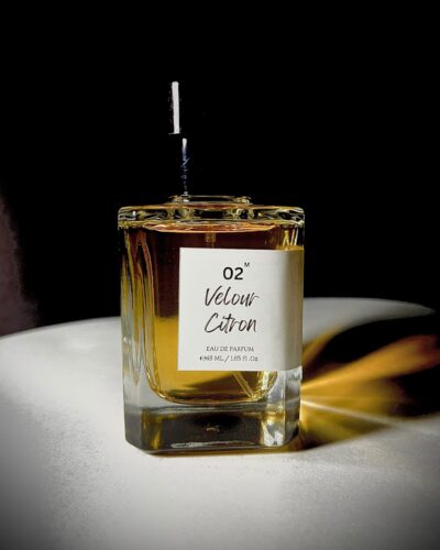 Glass perfume bottle of Bois et Fleurs Parfums featuring notes of pink pepper, lime, lavender, frankincense, vanilla, whipped cream, and dark chocolate.