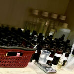 Fragrance material trials with perfume blotters, vials, and raw ingredients in the background.